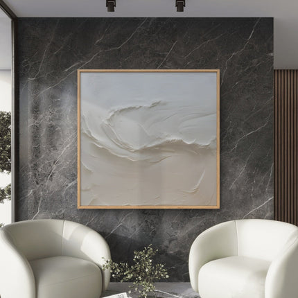 Modern living room with two white armchairs and a abstract painting on a marble wall.